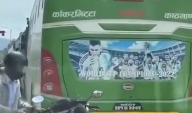 忠实拥趸！一位球迷在堵车时擦拭大巴上的梅西海报，清理灰尘